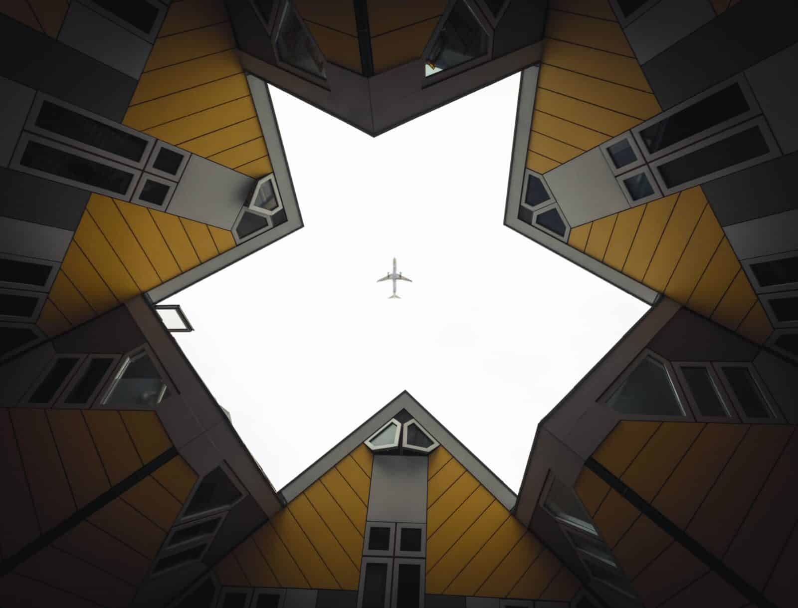 A commercial airplane flying over buildings